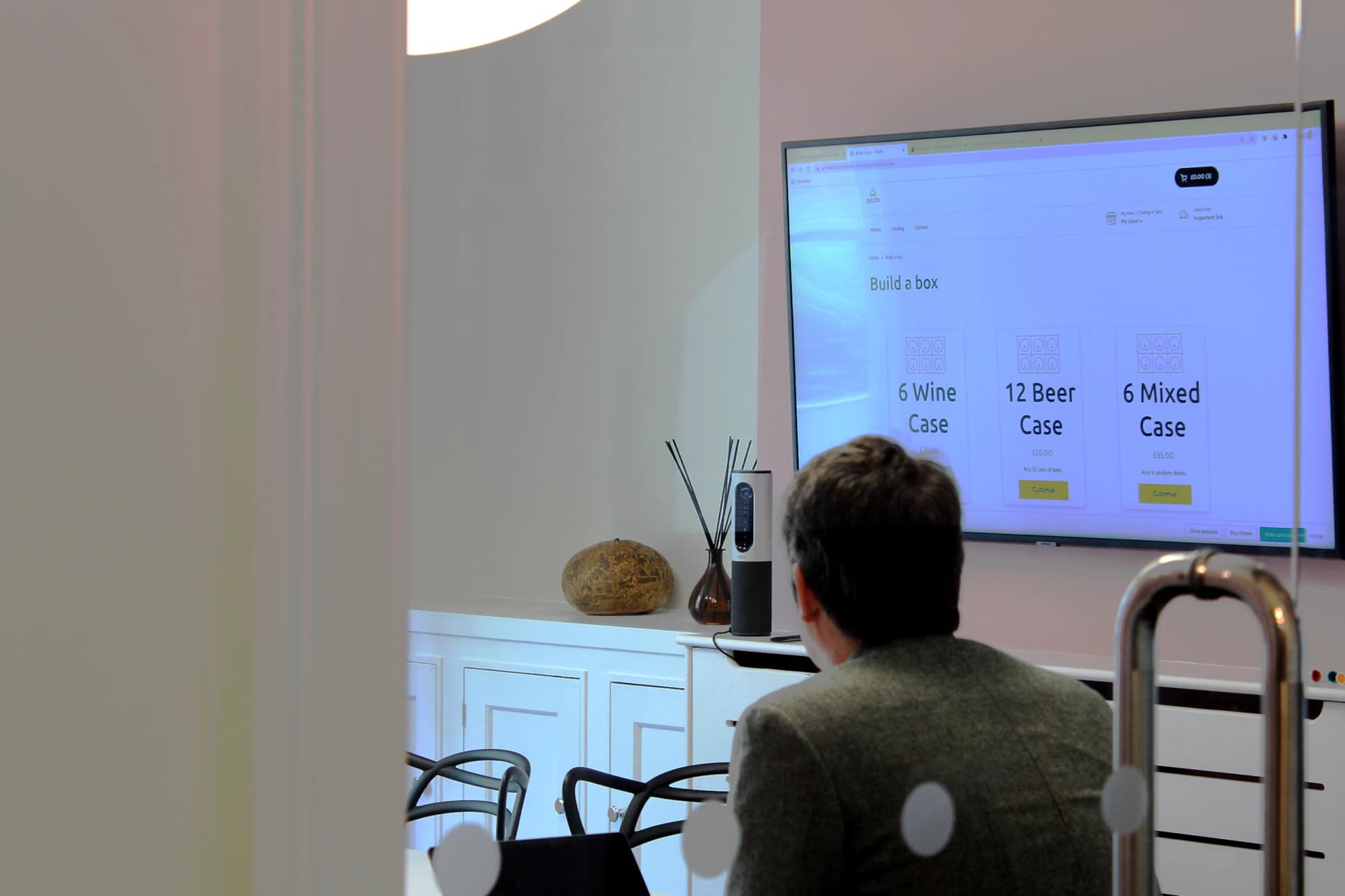 Digital Director and co-founder Mat sits in boardroom with large screen showing early-stages website build