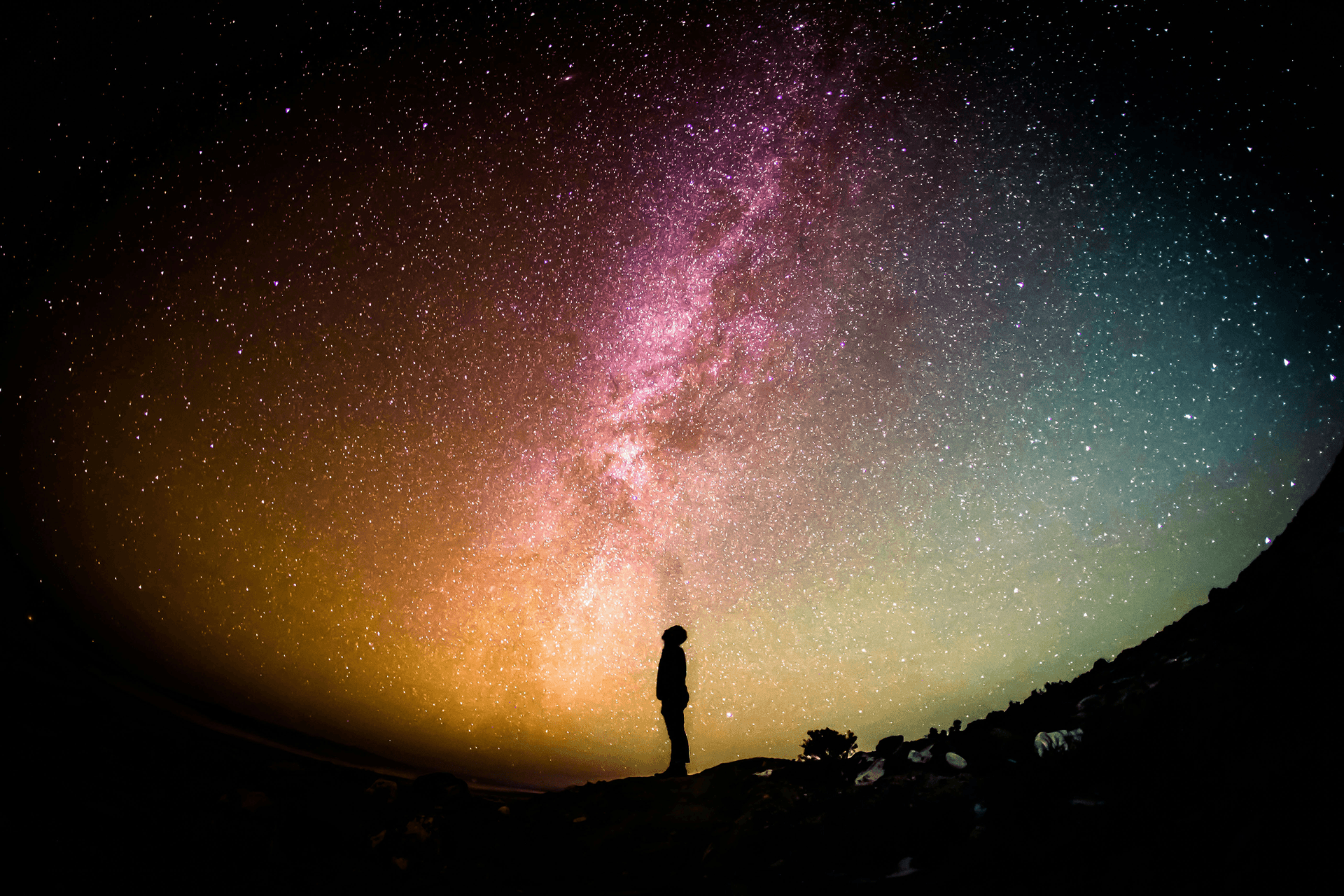 A person looks to a colourful night sky symbolising Progressive Web Apps in the context of Apple's response to the EU digital markets legislation.